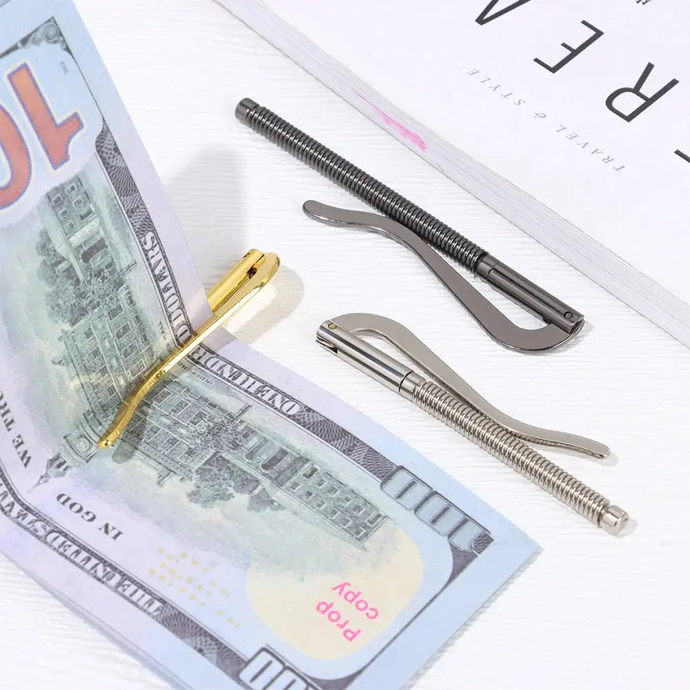 Three-piece metal money clip replacement parts set with gold-tone clip and two spring clamps beside a banknote