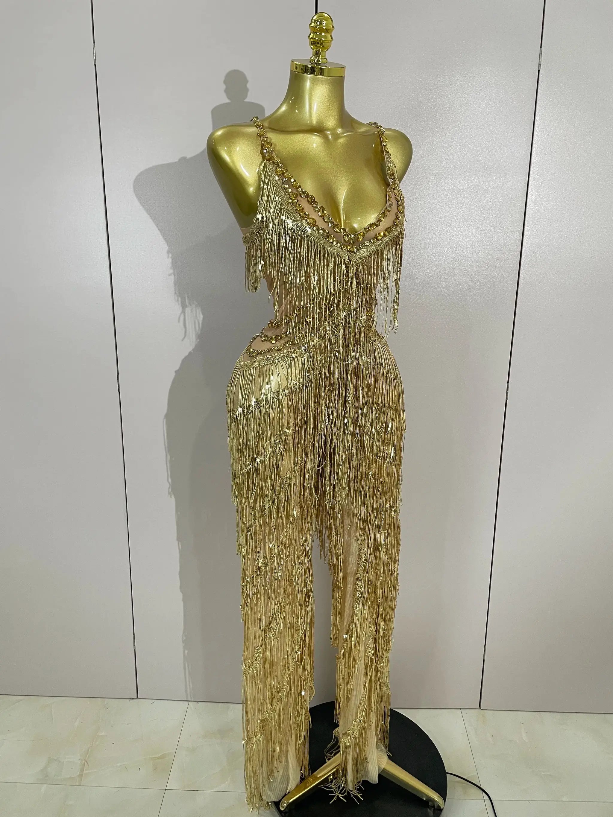 Gold sequined fringe jumpsuit by Simples Market on mannequin, long beaded tassels, glamorous stage costume