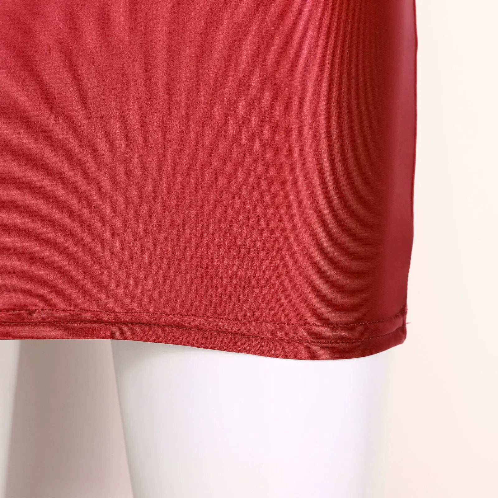 Red glossy patent leather mini skirt on a mannequin.