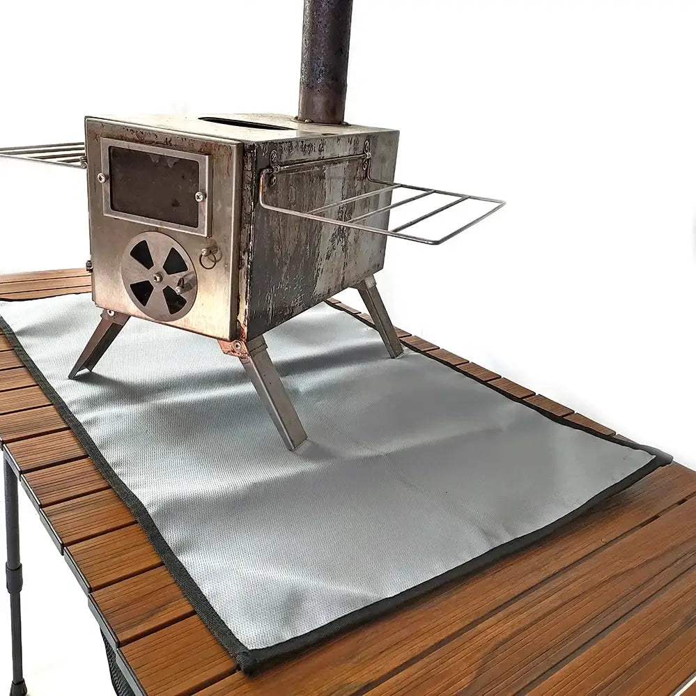  Camping Fireproof Cloth BBQ Grill Mat Simples Market; silver-gray heat-resistant protective mat under a camping stove.