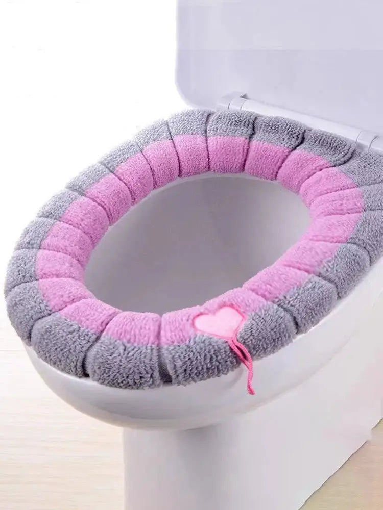 Thick plush toilet seat cover pad in pink and gray with pink heart accent, soft, stretchable cushion for comfort.
