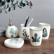 White ceramic bathroom set, 5-piece with green botanical pattern.