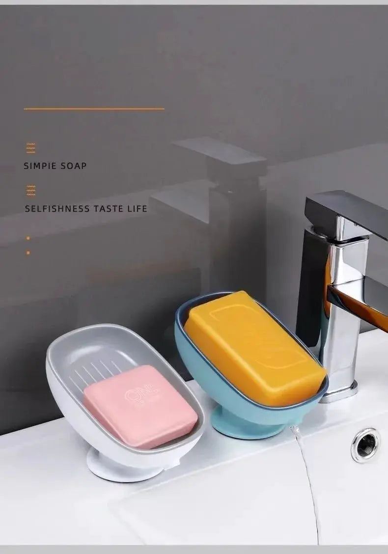 Suction cup soap holders on bathroom sink; white holder with pink soap and blue holder with yellow soap.