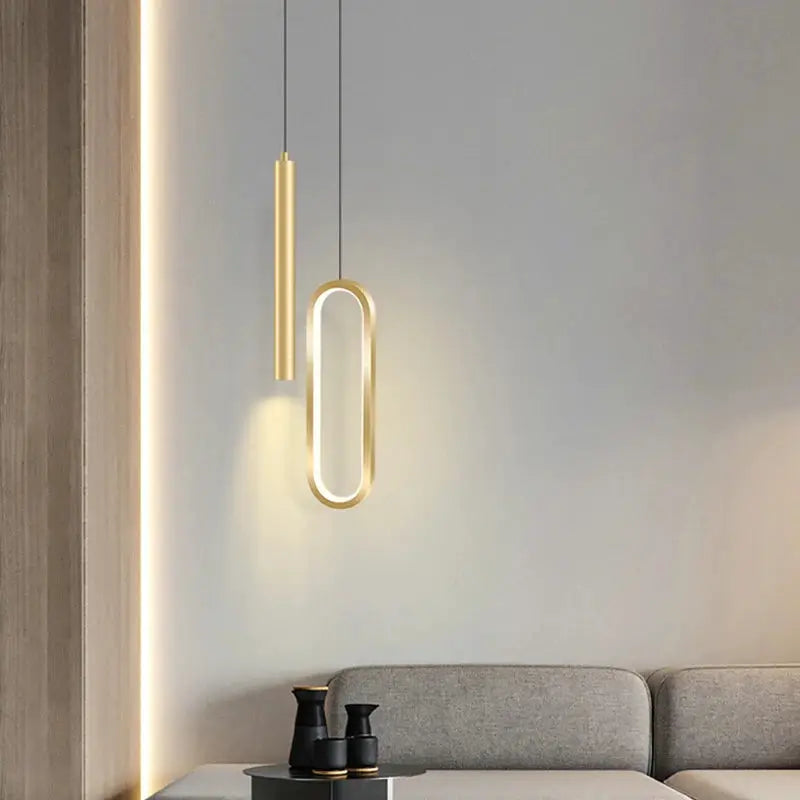 Nordic LED pendant light set with two gold-finish hanging lamps, oval loop design for modern living spaces.
