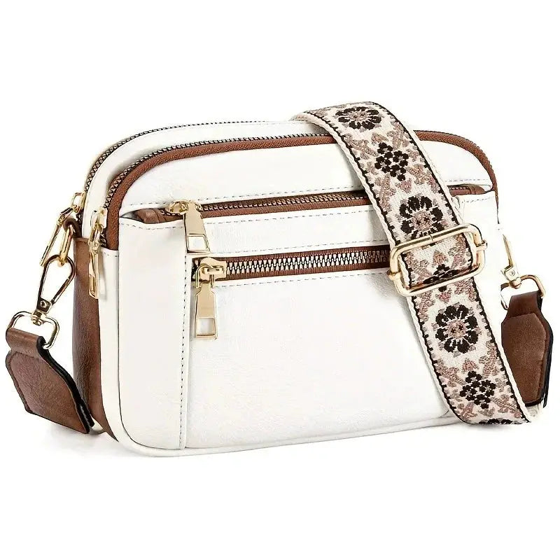 Women's small square crossbody bag in white with brown zippers and floral-patterned strap