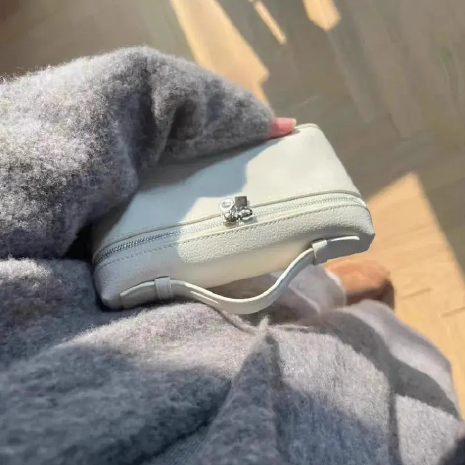 Mini white lychee-grain shoulder bag with dual zipper, handheld crossbody style.