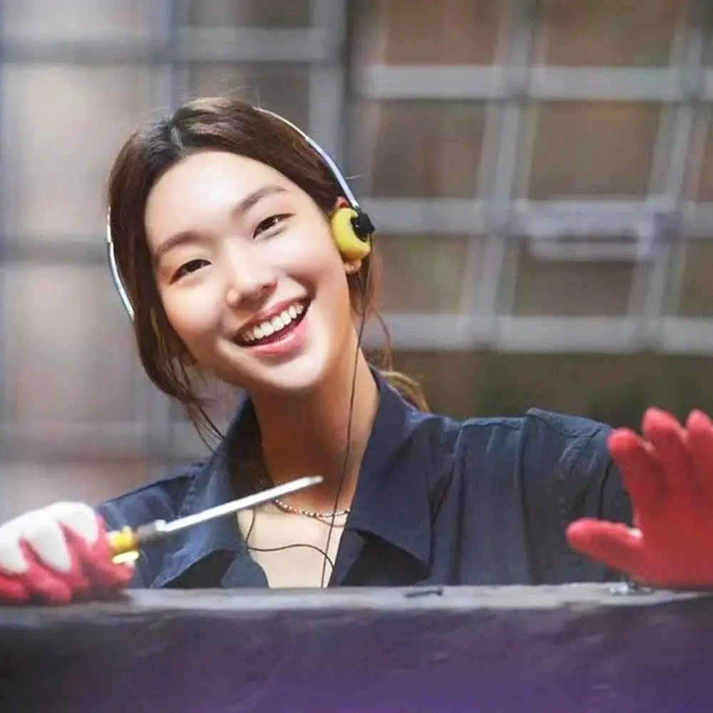 On-ear wired stereo headphones in yellow worn by a smiling woman.