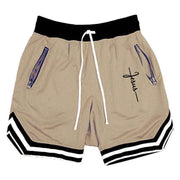 Men's beige basketball shorts with black waistband, white drawcord, blue zip pockets, and black‑and‑white striped hems