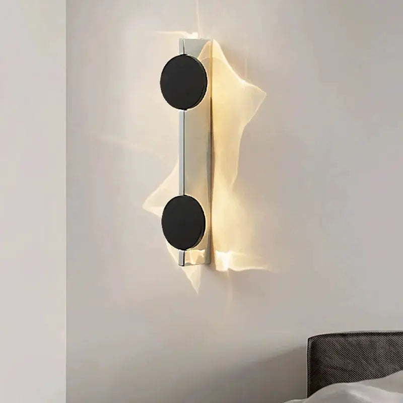 Modern LED wall light with stainless steel finish, rotatable corrugated wall lamp with two black circular discs.