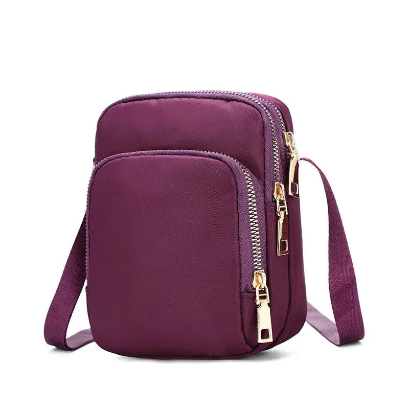 Women’s purple waterproof crossbody bag with two zip compartments and gold zippers