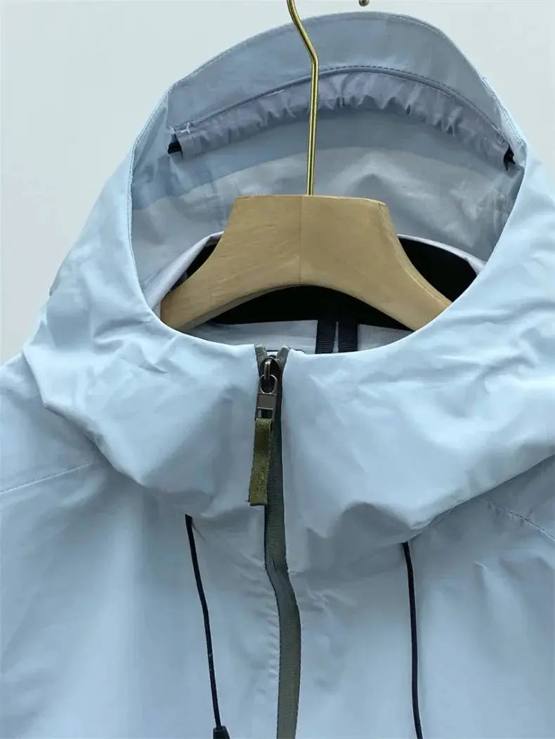 Men's windproof soft-shell outdoors jacket in light blue with hood and front zipper