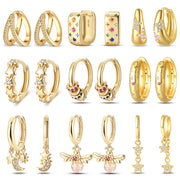 Gold-tone 15-piece earring set with hoops, huggies and charm studs featuring stars, moons, bees, pearls and crystals.