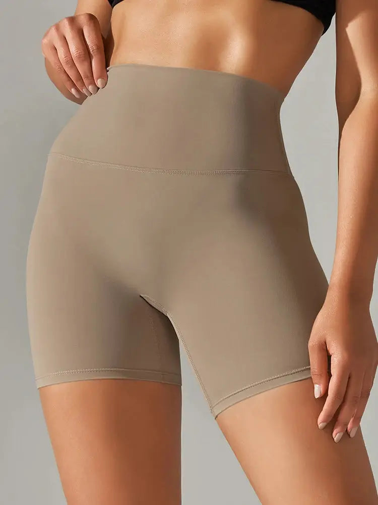 Beige high-waist women's yoga shorts, tight fit, mid-thigh length