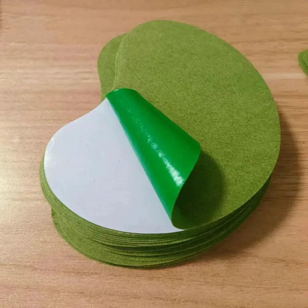 Green round neck and shoulder warming patches with white adhesive backing, stacked
