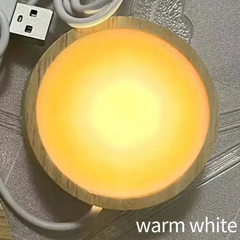 Round wooden LED night light base with warm white glow and USB cable