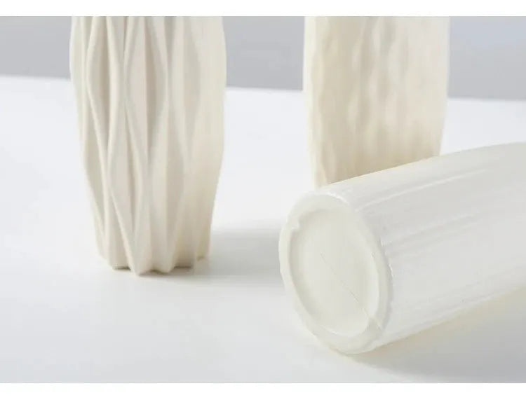 Three white Nordic plastic vases with ribbed texture, decorative flower pots.