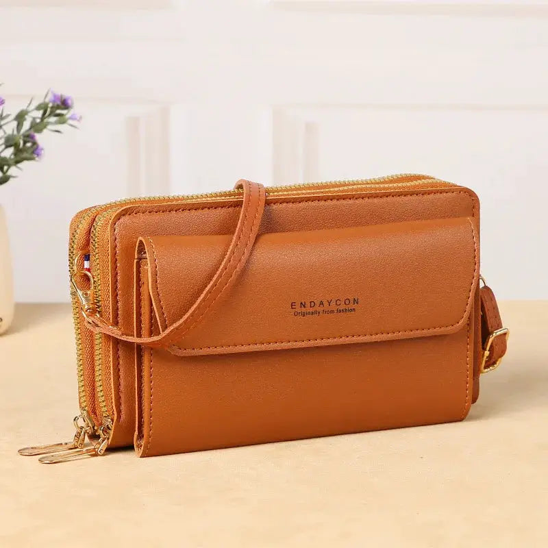 Crossbody bag in tan leather with double zipper pockets and adjustable shoulder strap; ENDAYCON
