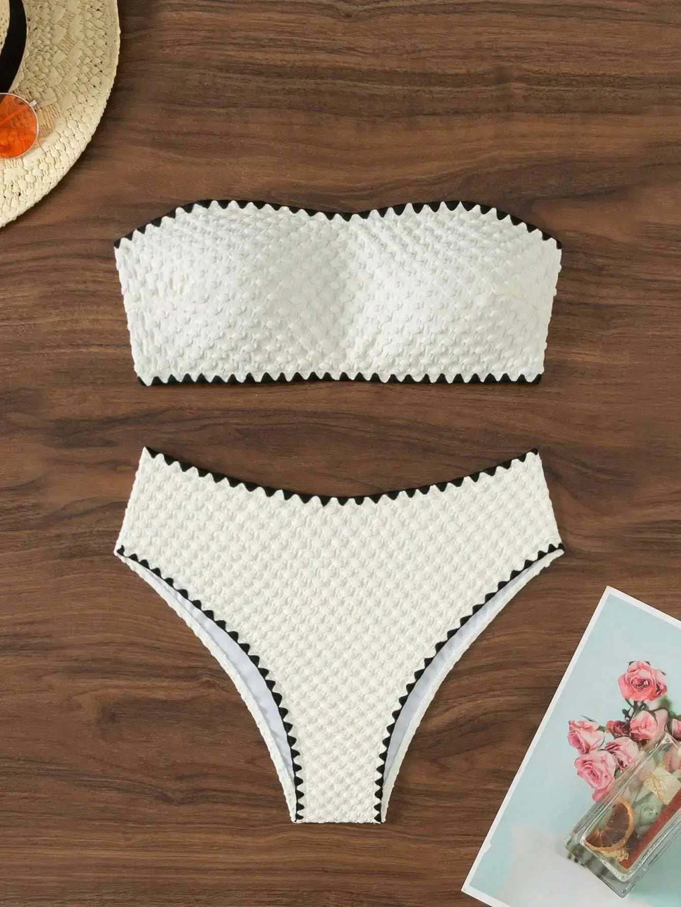 Two-piece white textured strapless bikini with bandeau top and thong-style bottom.