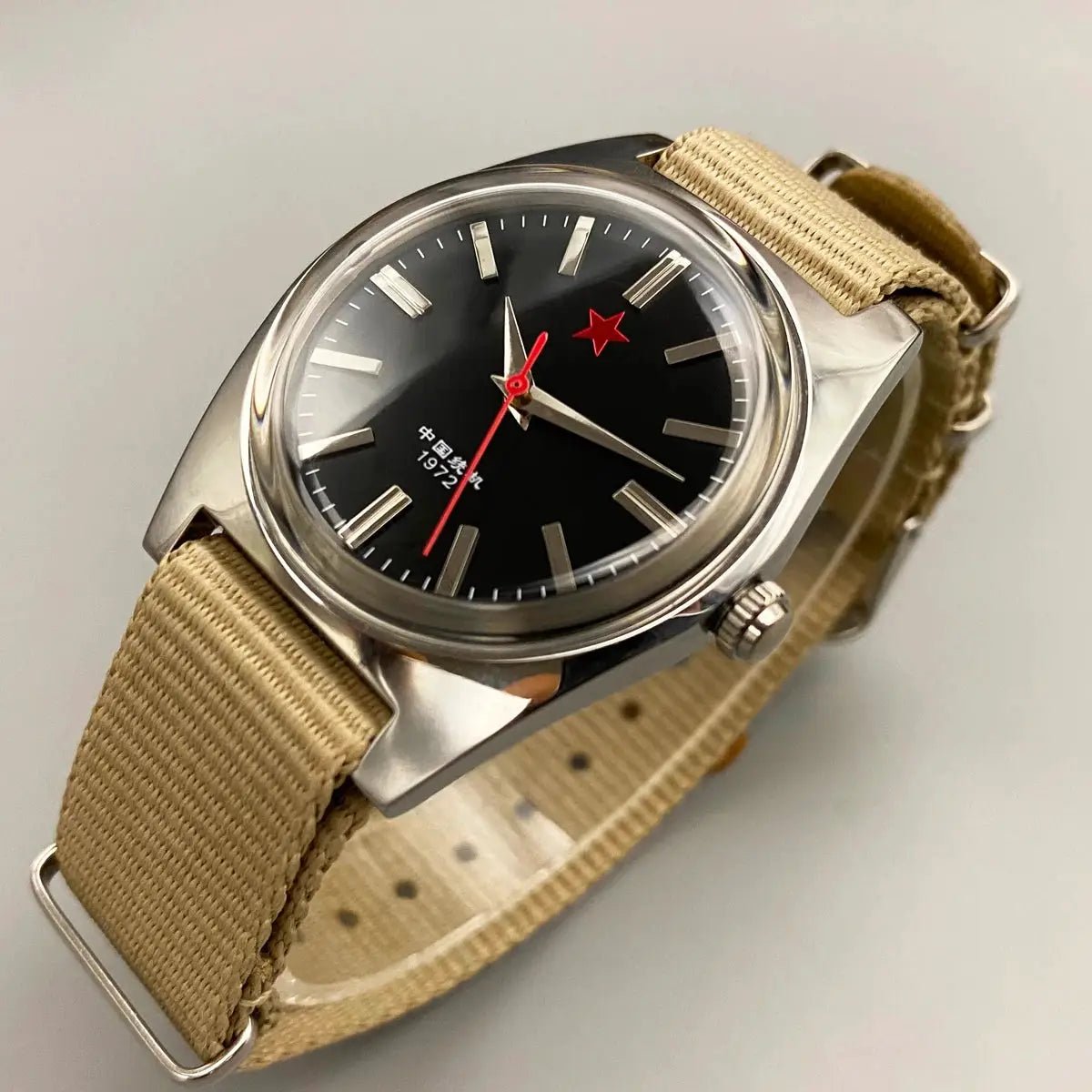 Men's 36mm mechanical watch; stainless steel case, black dial with red star, beige fabric strap.