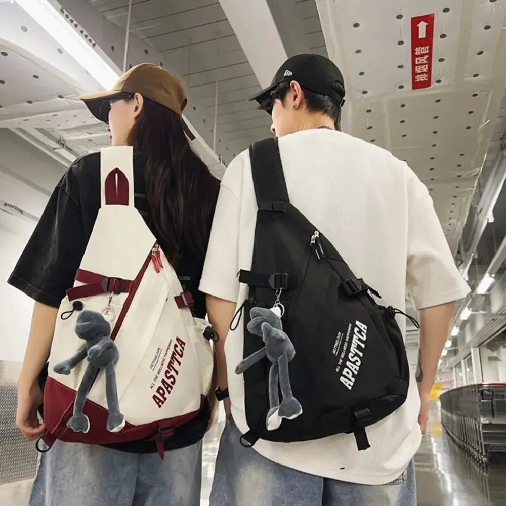Pair of Y2k nylon crossbody bags by Simples Market; white/red and black unisex backpacks with gray plush keychains.