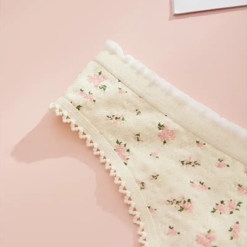 Women's floral print panties with cream lace trim and white pom-pom edging