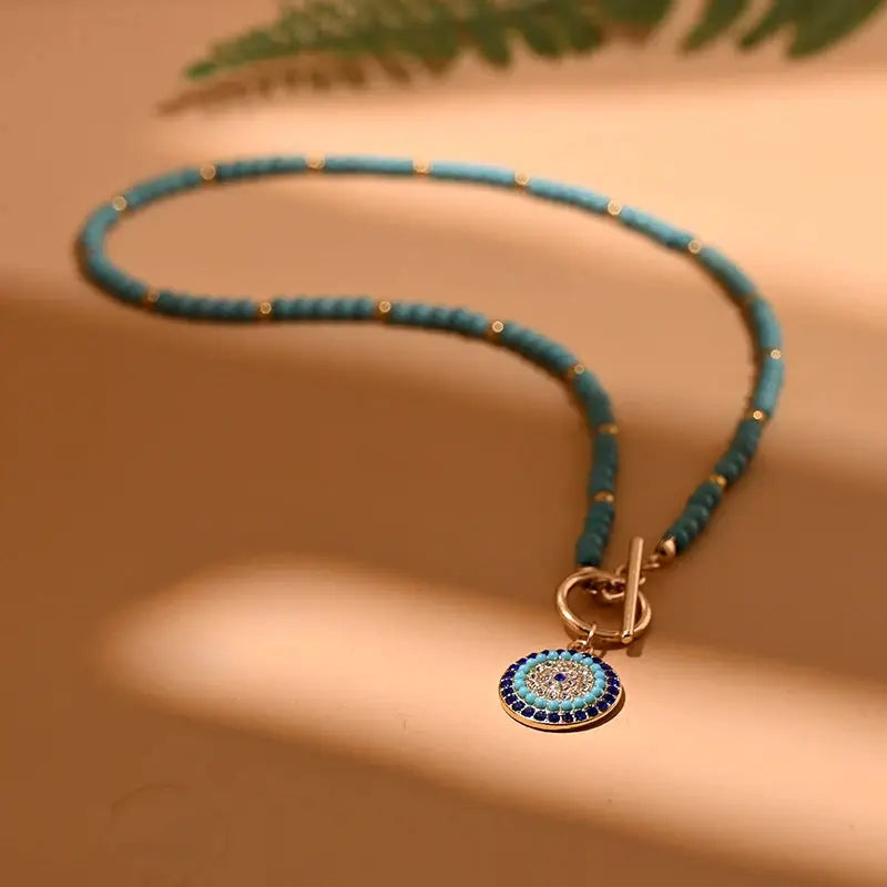 Turquoise beaded choker necklace with a round blue evil charm pendant