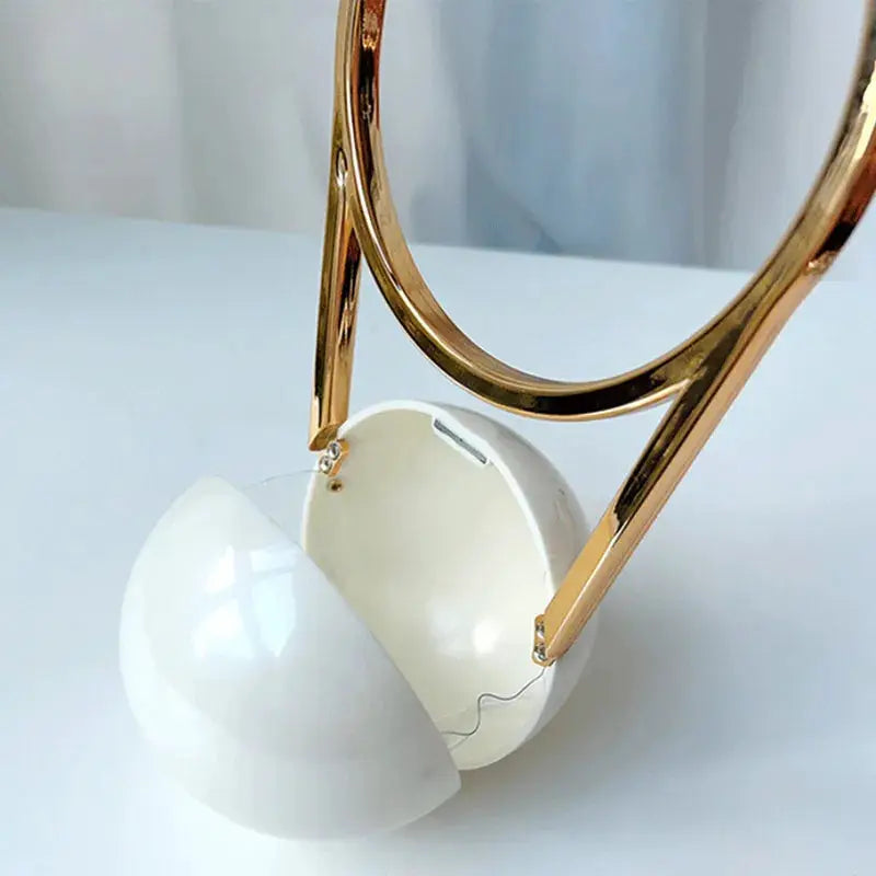 Luxury acrylic evening clutch with gold ball-handle and white spherical clasp.