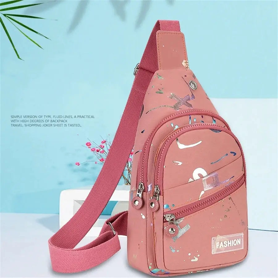 Pink chest bag crossbody sling backpack with paint-splatter design and multiple zip pockets
