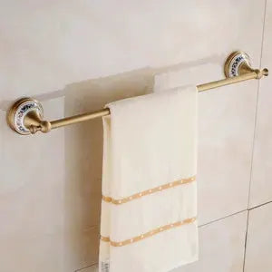Antique brushed brass wall-mounted towel bar with porcelain end caps for bathroom hardware set