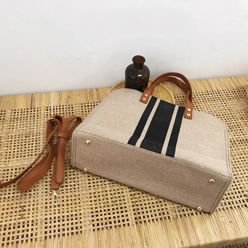 Simples Market canvas stripe tote bag with brown leather top handles and detachable strap; beige with black stripes