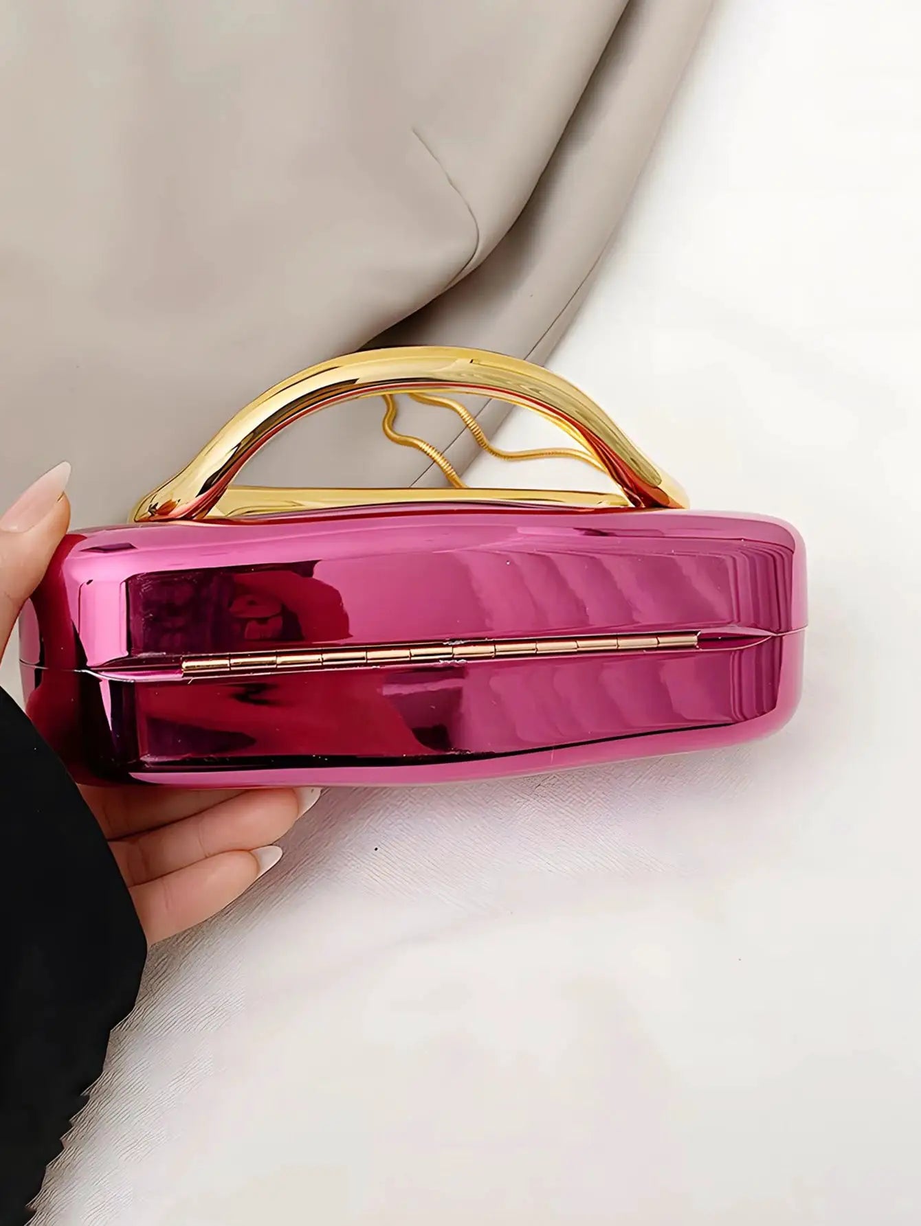 Acrylic box-shaped crossbody bag in pink with a gold-tone curved handle.