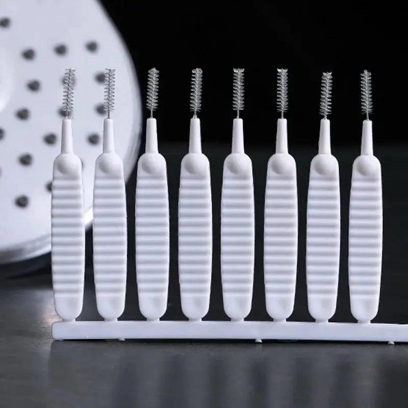 Shower cleaning brush set with white plastic handles and micro nylon bristles arranged on a stand