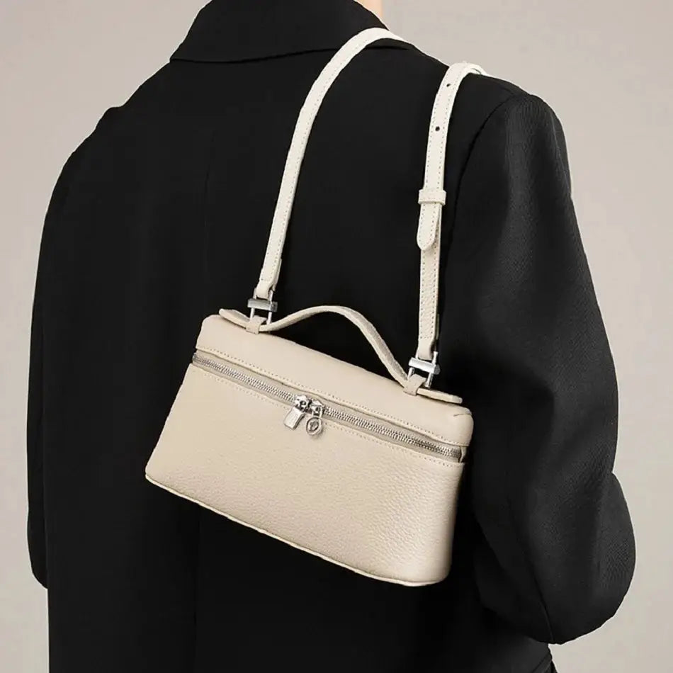 Beige lychee-grain mini shoulder bag with top handle and adjustable crossbody strap, silver hardware.
