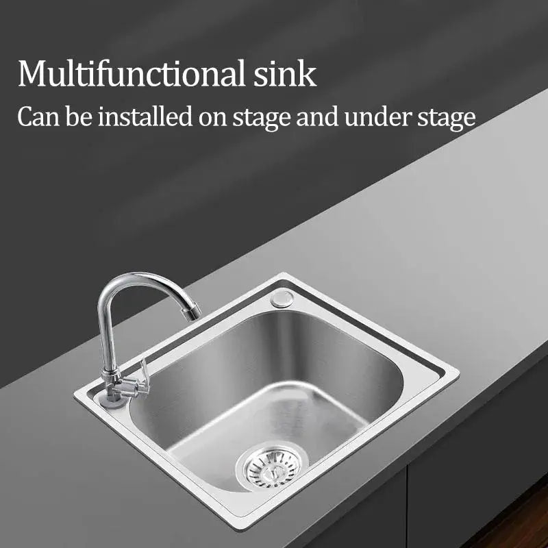 Stainless steel single-basin kitchen sink with chrome faucet on gray countertop.