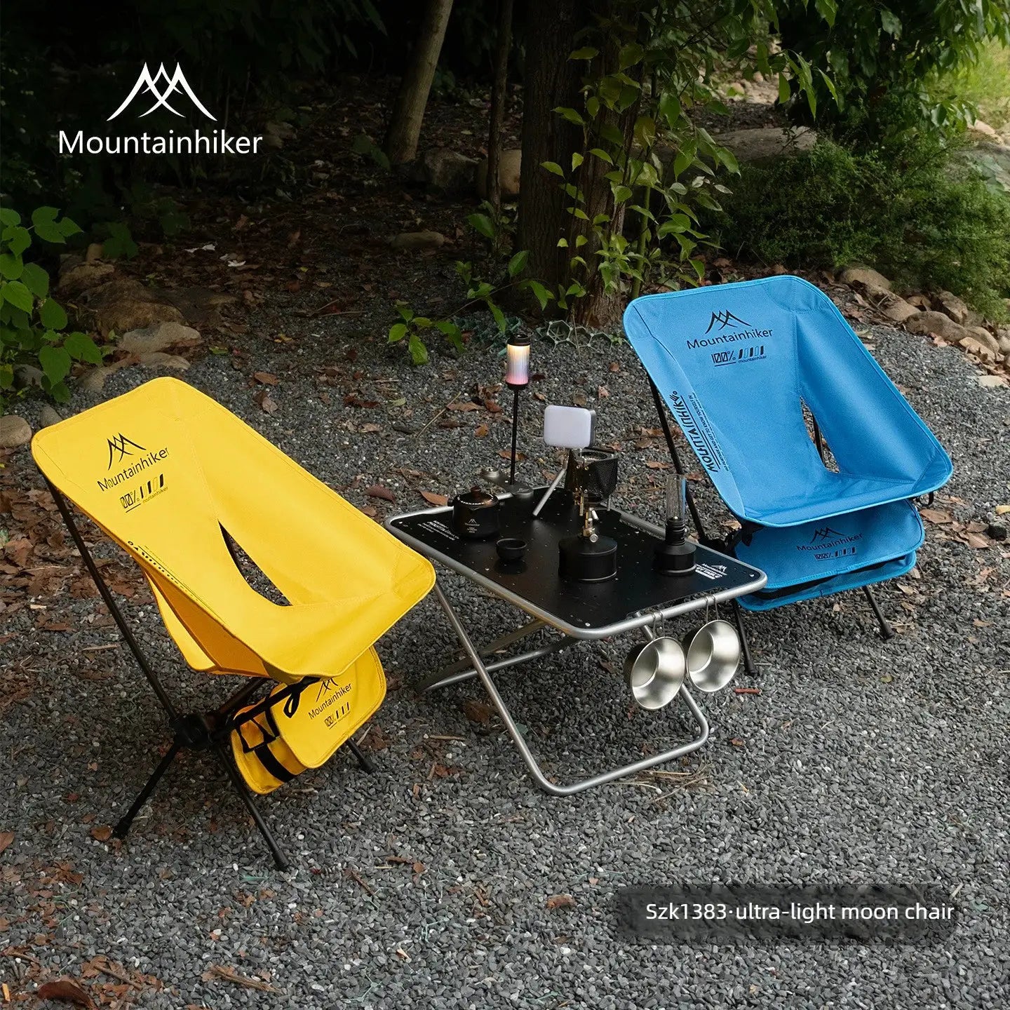 Foldable camping moon chair set by Simples Market; yellow and blue ultralight chairs beside a compact cooking table.