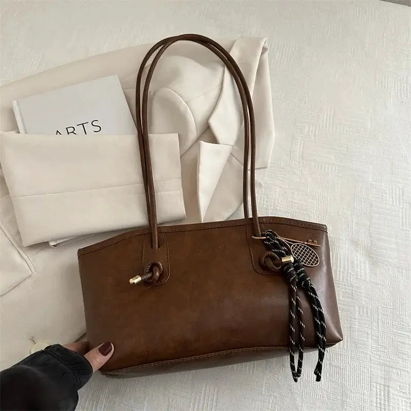 European American tote bag, brown leather with double handles and a black-and-white tassel pendant, large capacity.