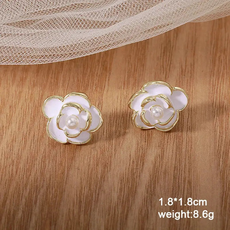 White flower acrylic enamel earrings with gold trim and pearl centers, Simples Market pair
