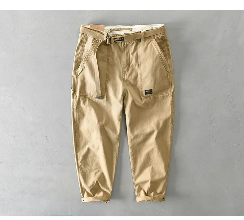 Men's beige cotton cargo pants with belt, loose fit and cuffed hems.