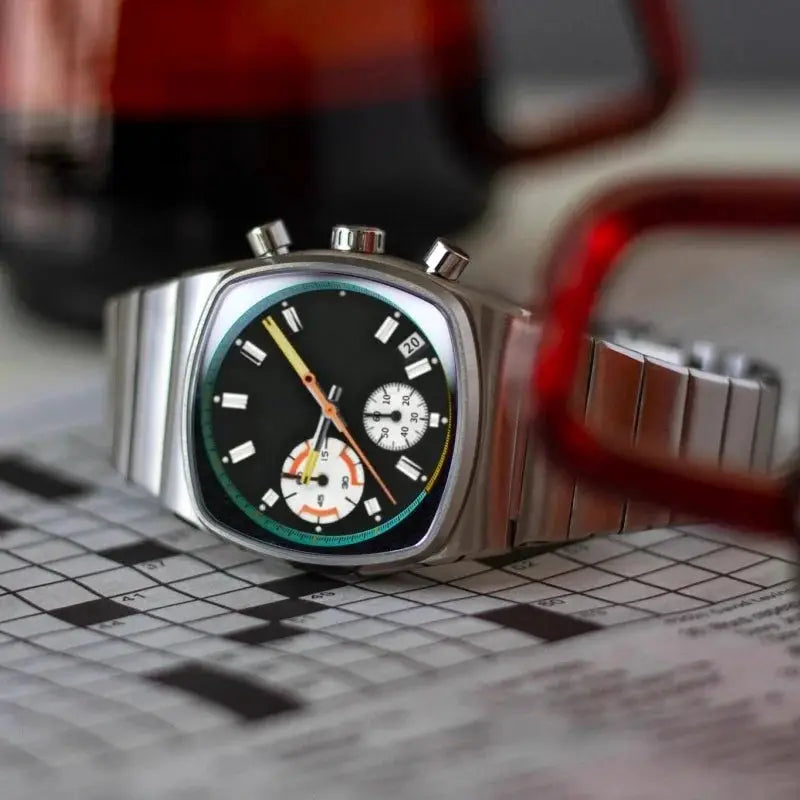Men's square stainless steel watch with black dial, chronograph subdials, and turquoise bezel