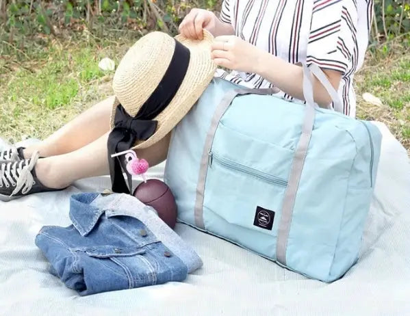 Large capacity travel bag by Simples Market in light blue with gray handles