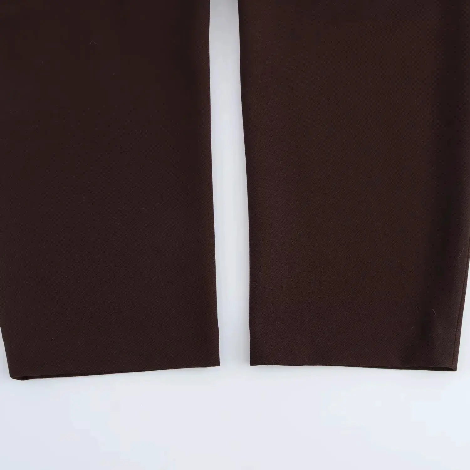 Pair of brown baggy pants with a white vertical center stripe, flat-lay display
