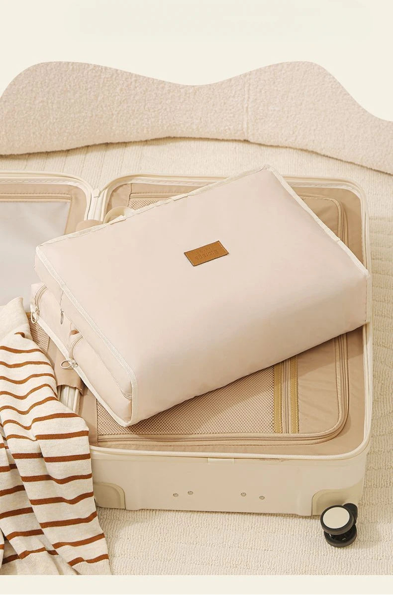 Business Travel Storage Hanging Bag by Simples Market, cream color, foldable underwear organizer on open suitcase.