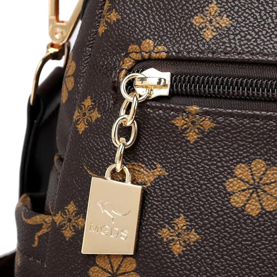 Ladies leather backpack in brown monogram print with gold hardware and MGDS tag.