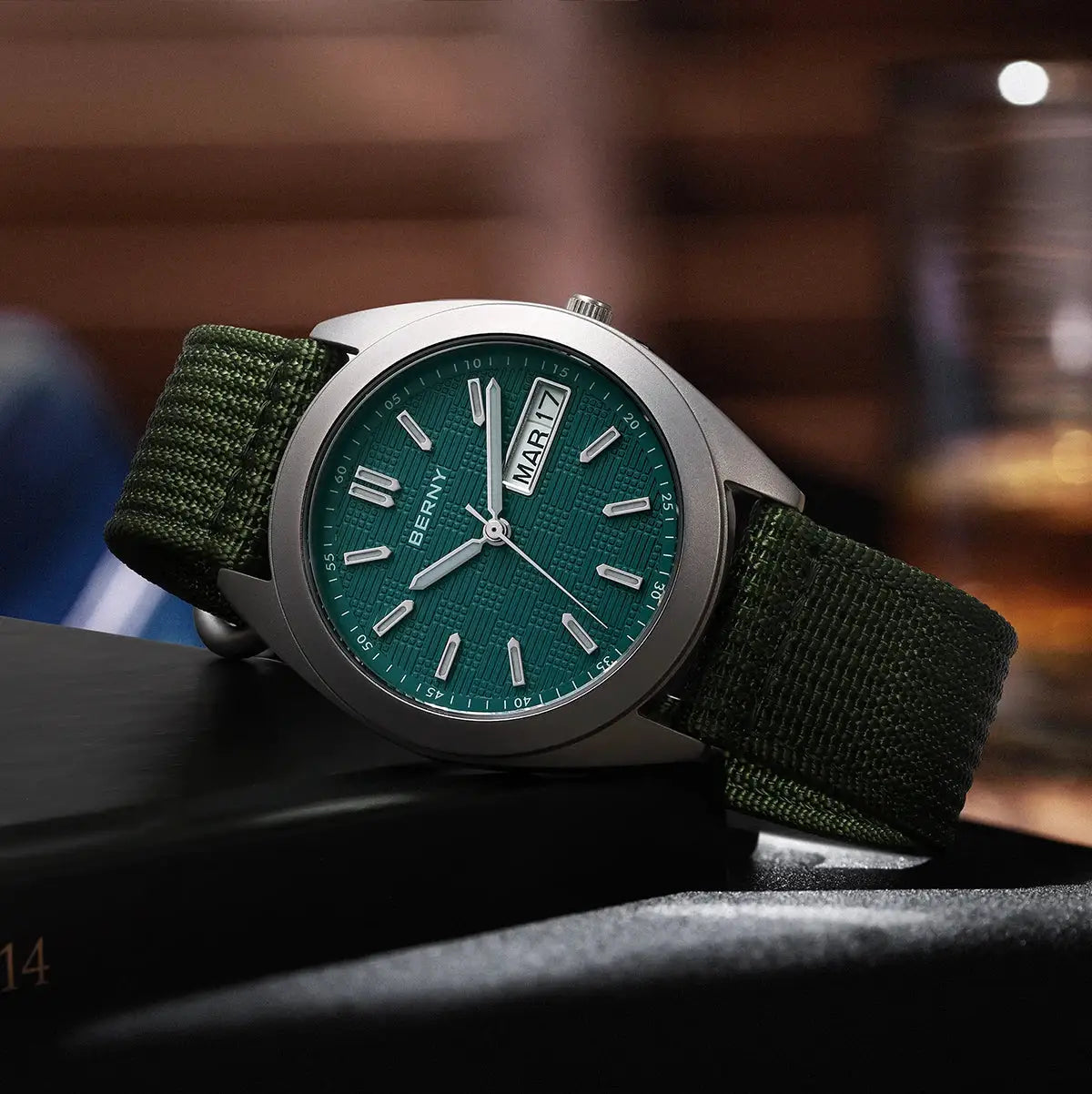 BERNY titanium men's watch with green dial, green fabric strap, and date window.
