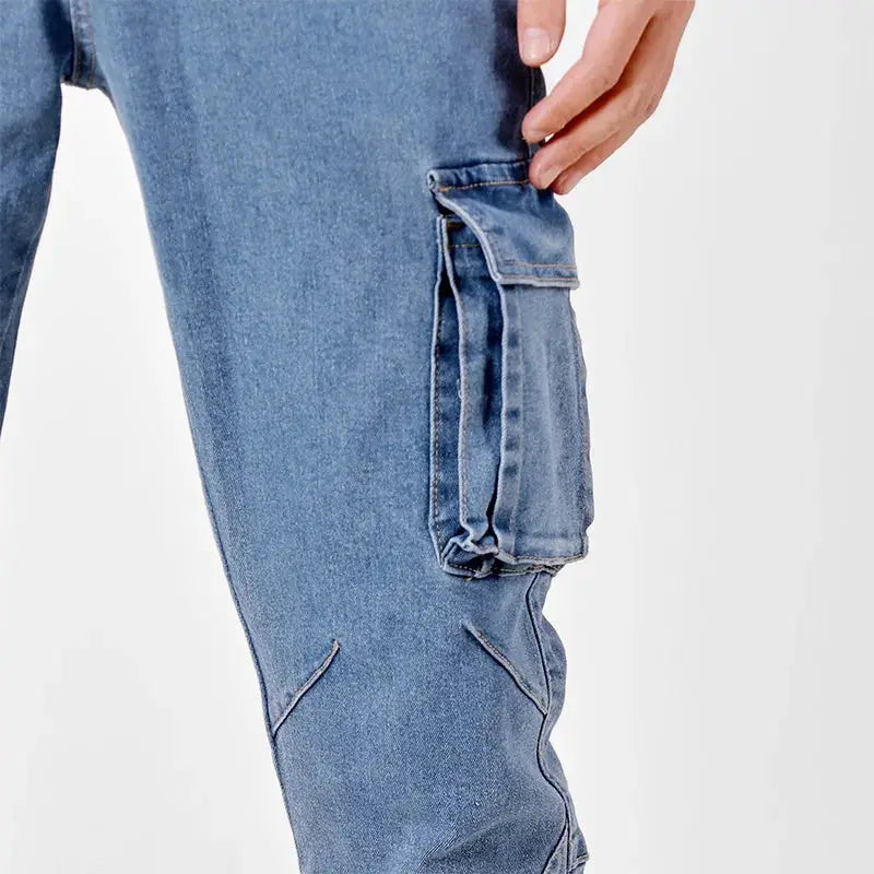 Men's denim cargo pants with elastic waist, washed blue finish, slim fit, multiple pockets.