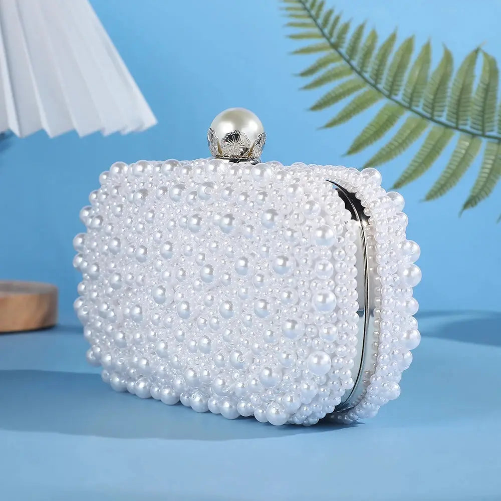 Pearl-studded white evening clutch with round pearl knob clasp and silver frame