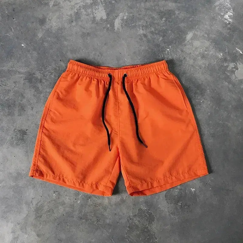 Men's orange swim shorts with elastic waistband and black drawstring, board shorts style.