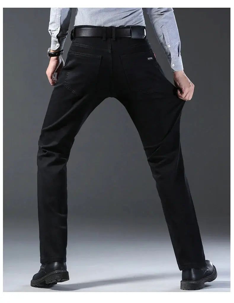 Men's black stretch denim jeans by Simples Market, slim straight fit with belt, back view.