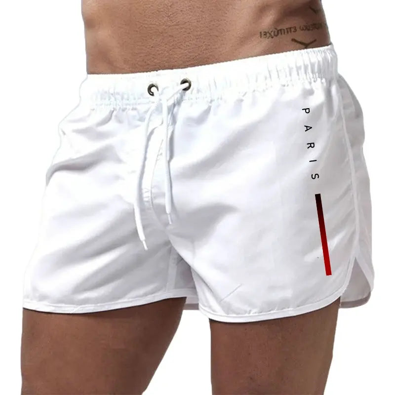 Men's white board shorts with drawstring, Paris branding and red vertical stripe.