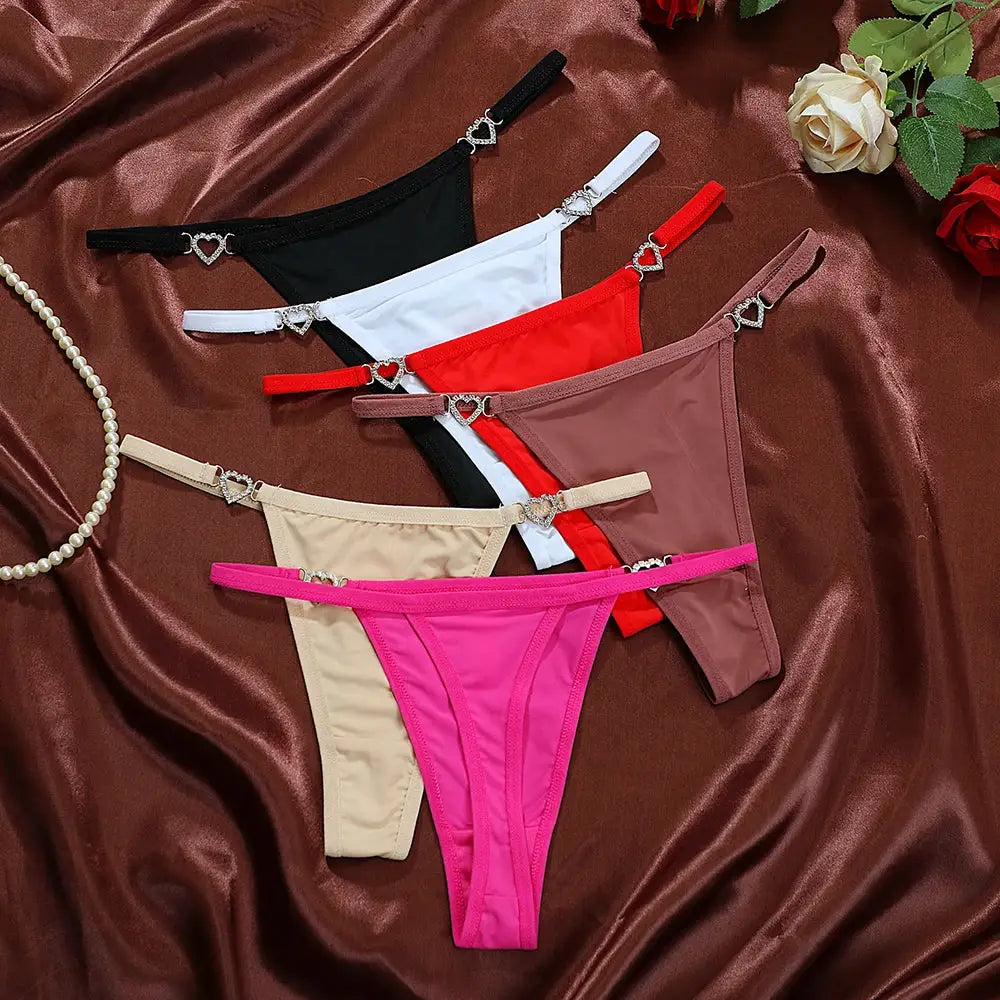 Six-piece women's thong set in black, white, red, nude, beige, and pink with heart charm on straps.